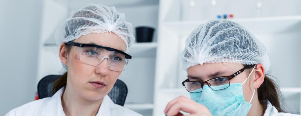 worker wearing hair net and another worker wearing hairnet and facemask