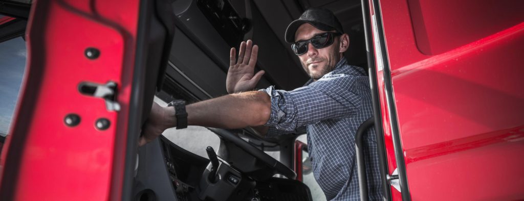 Truck driver waving from open truck door